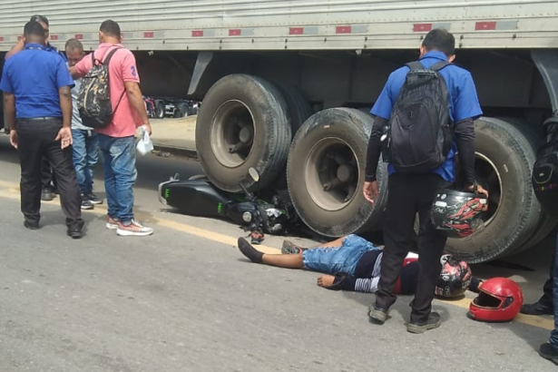 Motociclista fica ferido ao bater em carreta; moto ficou sob rodas do veículo